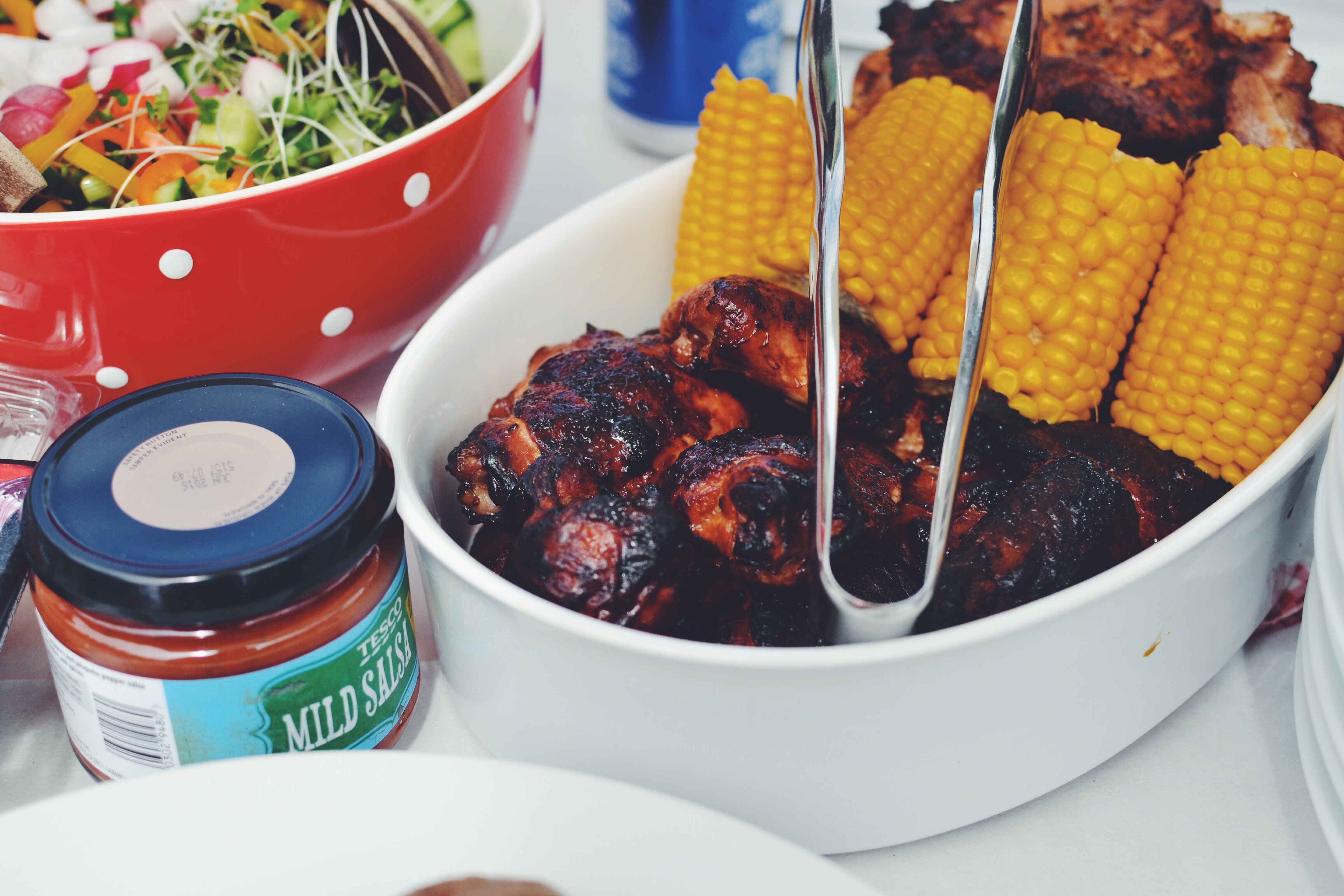 Close up of chicken drumsticks and corn on the cob