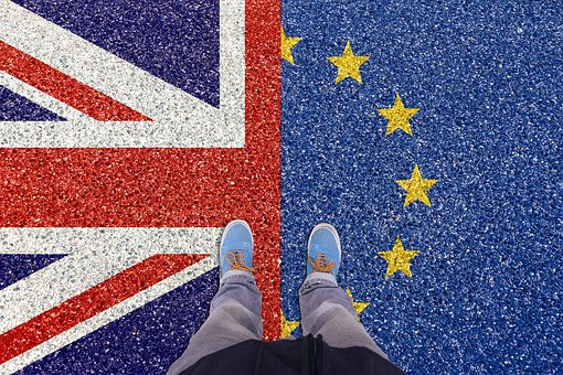 Person standing on either side of UK and EU flags